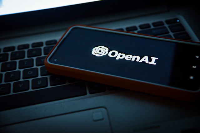 OpenAI logo on phone sitting on keyboard