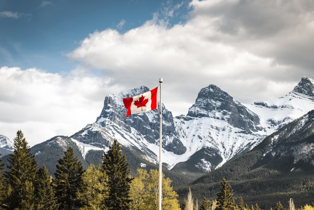 canadian flag with mountains behind it