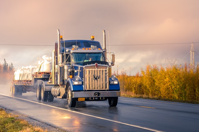 blue semi truck driving on road
