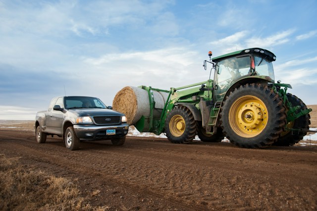 pickup truck and tractor in field