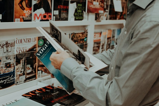 person browsing Vogue at magazine stand