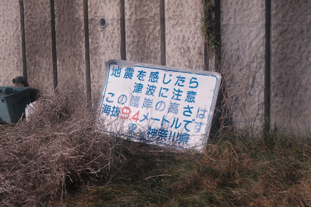 earthquake warning sign on sea wall in Japan